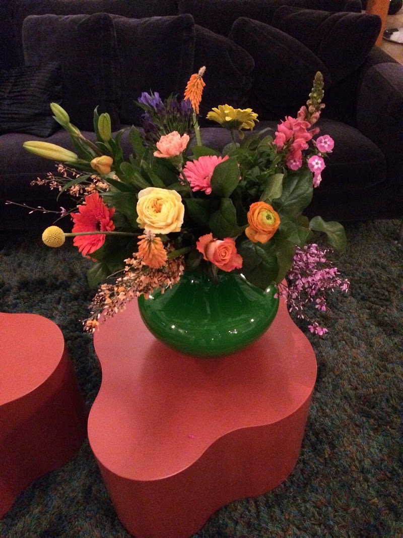 Het boeket in een groene vaas op een bijzettafel in de woonkamer van de ontvanger.